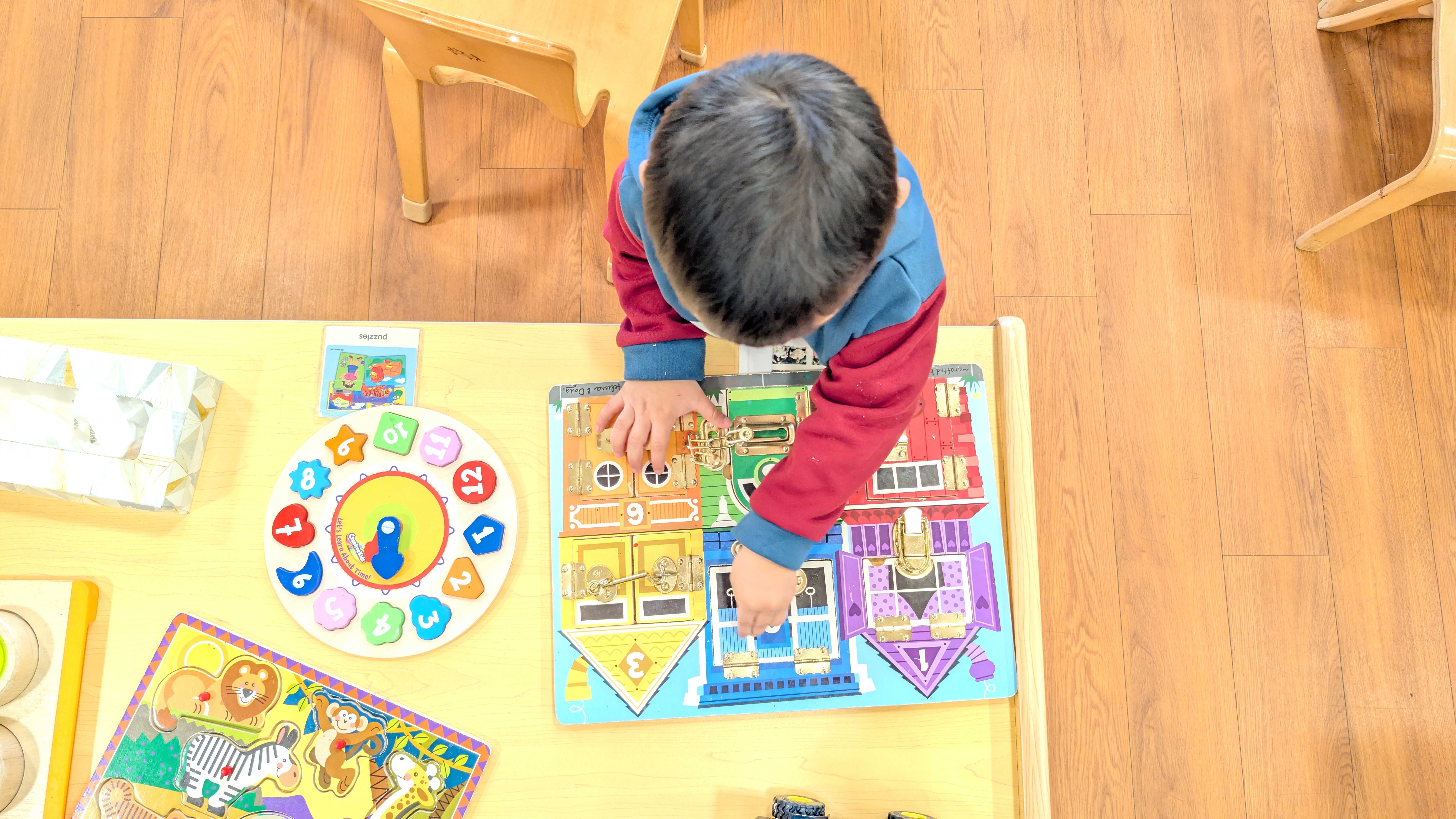 A child finishes a puzzle in a brightly-lit classroom.