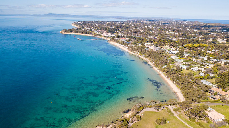 Drone image of ocean, beach and land in Nepean ward