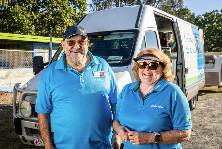 Two volunteers standing in front of an RSPCA Queensland animal transfer van